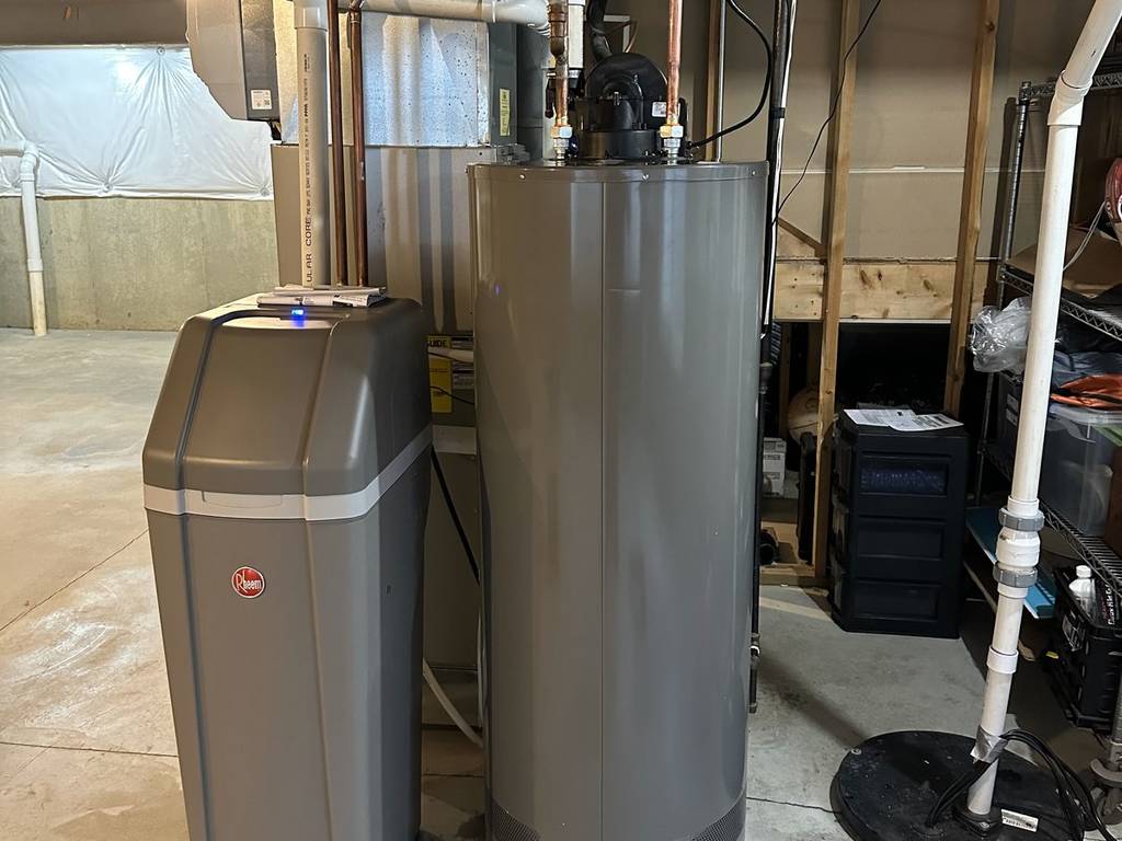 Water softener installed next to a water heater by Urban Plumbing